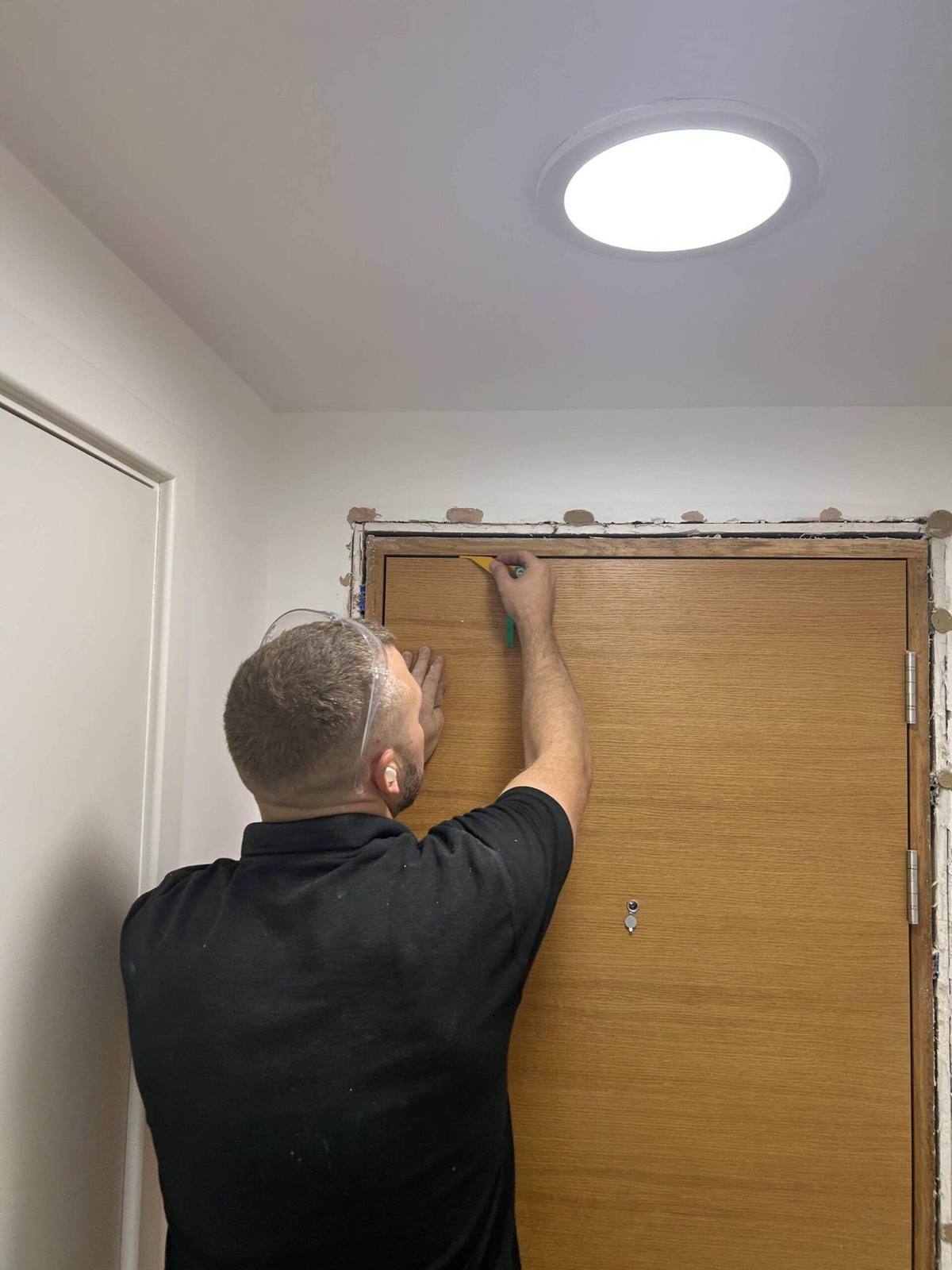 Vanguard engineer fitting a new fire door